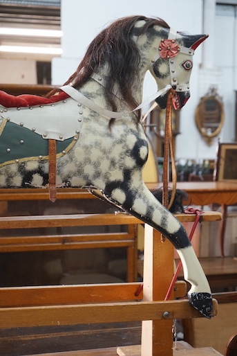 A vintage Ayres type dapple grey carved wood rocking horse on beech safety frame, length 130cm, height 115cm